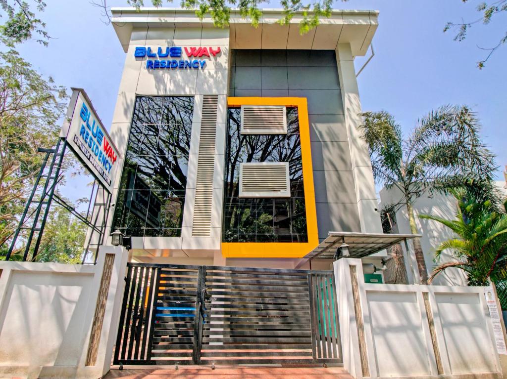 een gebouw met een gele deur en een trap voor de deur bij BLUEWAY RESIDENCY BUSINESS BOUTIQUE HOTEL in Trivandrum