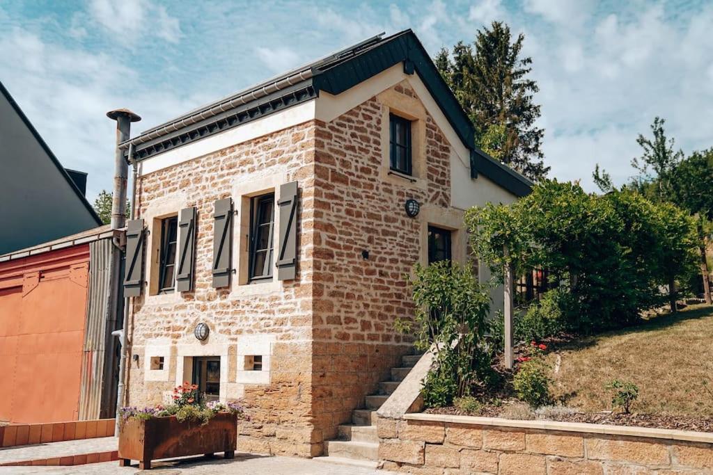 une maison en briques avec un escalier en face de celle-ci dans l'établissement Den Alen Arbed's Büro, à Kayl