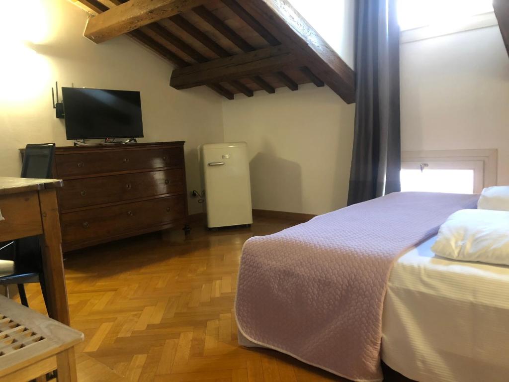 a bedroom with a bed and a dresser with a television at Residenza Privata Pedrotti in Vicenza