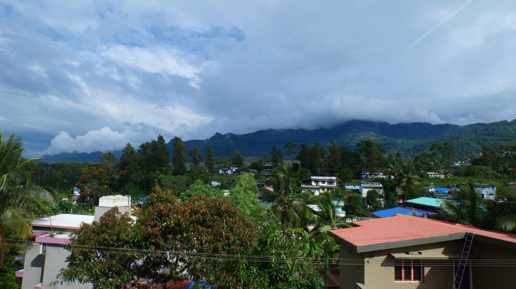 vistas a una ciudad con montañas en el fondo en Hillside Hideaway Gudalur, en Gūdalūr