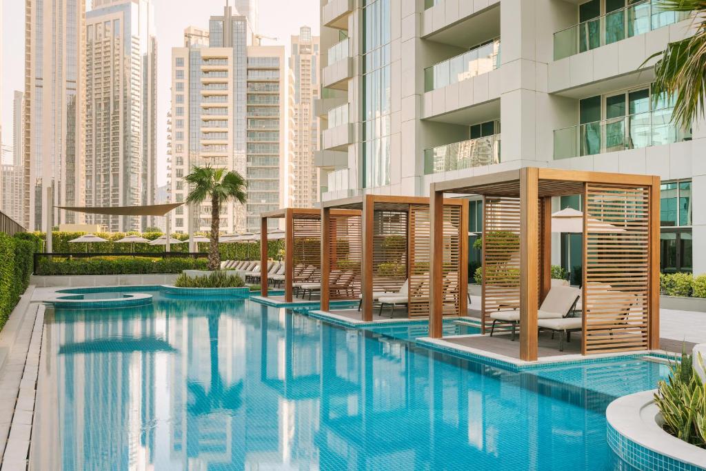 una piscina con sedie e un edificio di Sonder Business Bay a Dubai