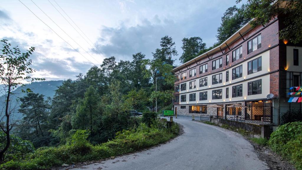 a dirt road next to a building on a hill at Tree of Life Indra Mandala Hotel, Gangtok in Gangtok