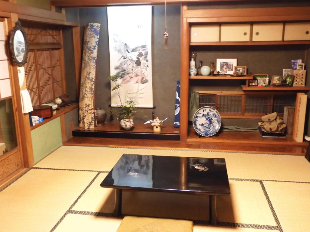 una sala de estar con una mesa y algunos estantes en Traditional Japanese House with beautiful garden, en Fujisaka