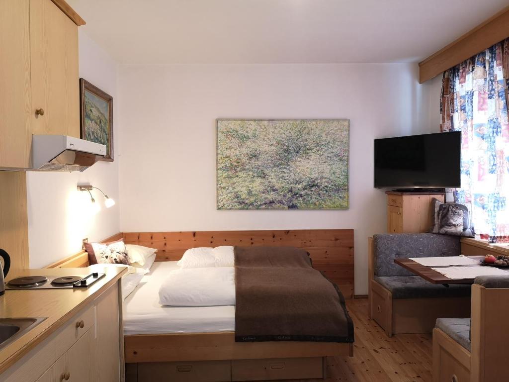 a small room with a bed and a kitchen at Molignon - Ortisei - Val Gardena in Ortisei