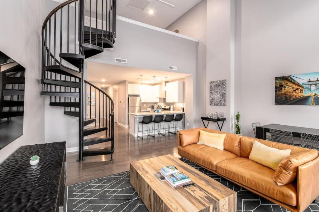 un soggiorno con divano e una scala di Soaring 2-Bedroom Parkside Loft Walkable to it All a Cincinnati