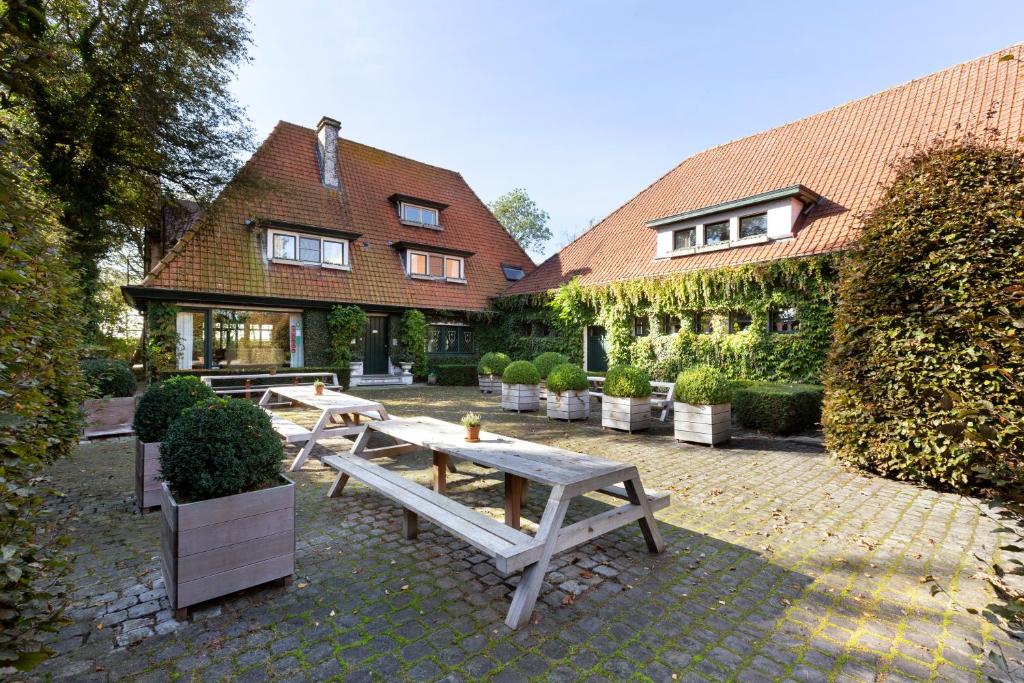 un patio con tavoli da picnic di fronte a una casa di Guesthouse Brouwershuis a Poperinge