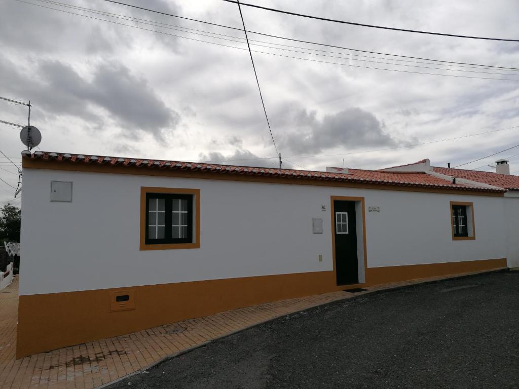 un edificio blanco con una puerta a un lado en A Casa da Carolina, en Mértola