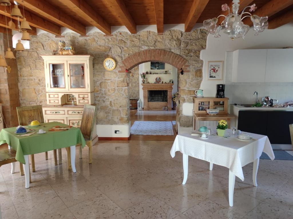 een woonkamer met 2 tafels en een keuken bij B&B QUINTARELLI in San Pietro in Cariano