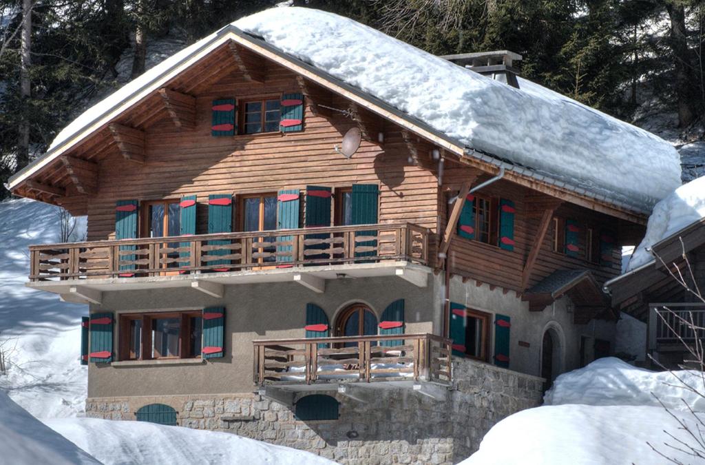 eine Blockhütte mit Schnee auf dem Dach in der Unterkunft La Ribambelle in Chamonix-Mont-Blanc