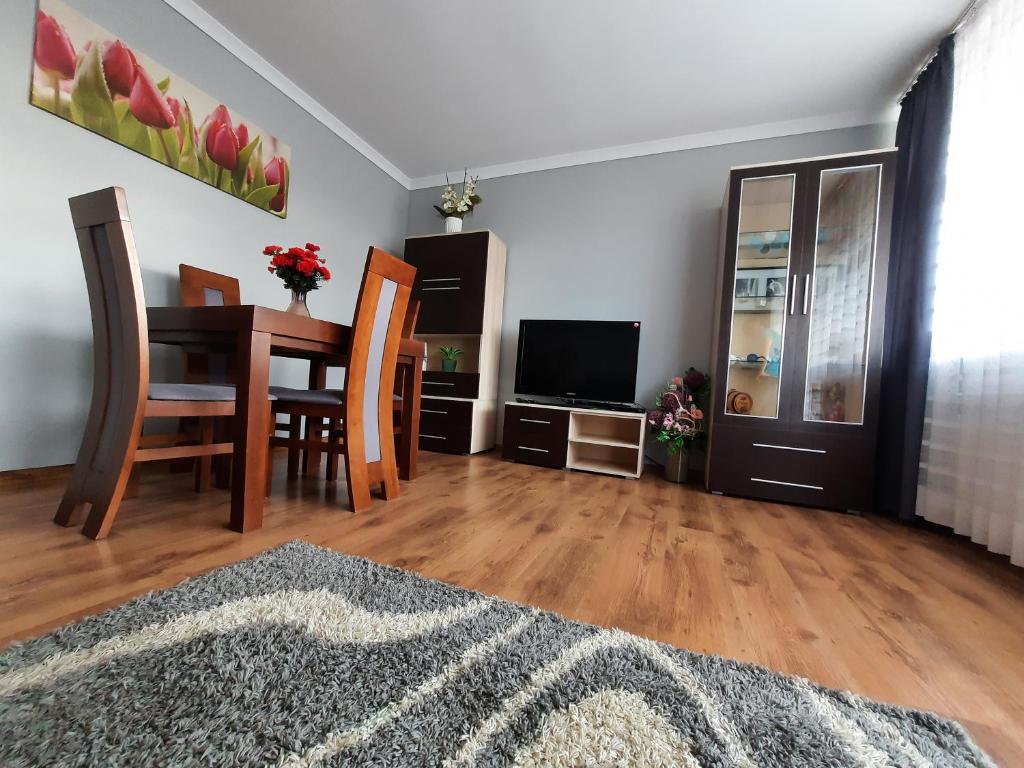 uma sala de estar com uma mesa e uma televisão em Słoneczny Apartament w Busku-Zdroju em Busko-Zdrój