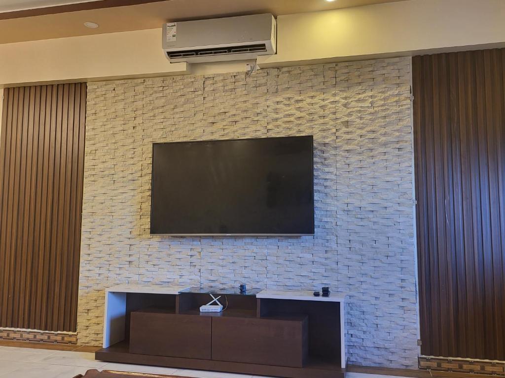 a flat screen tv on a brick wall at Meshaal heights in Mombasa