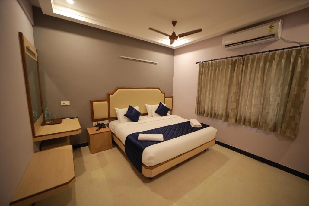 1 dormitorio con 1 cama extragrande y ventana en Majestic Hotel, en Madurai