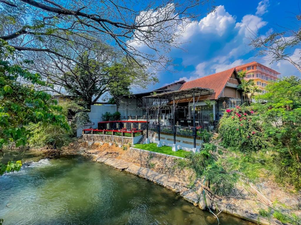 een huis met een rivier ervoor bij Rimtarn Hotel Pakchong in Pak Chong