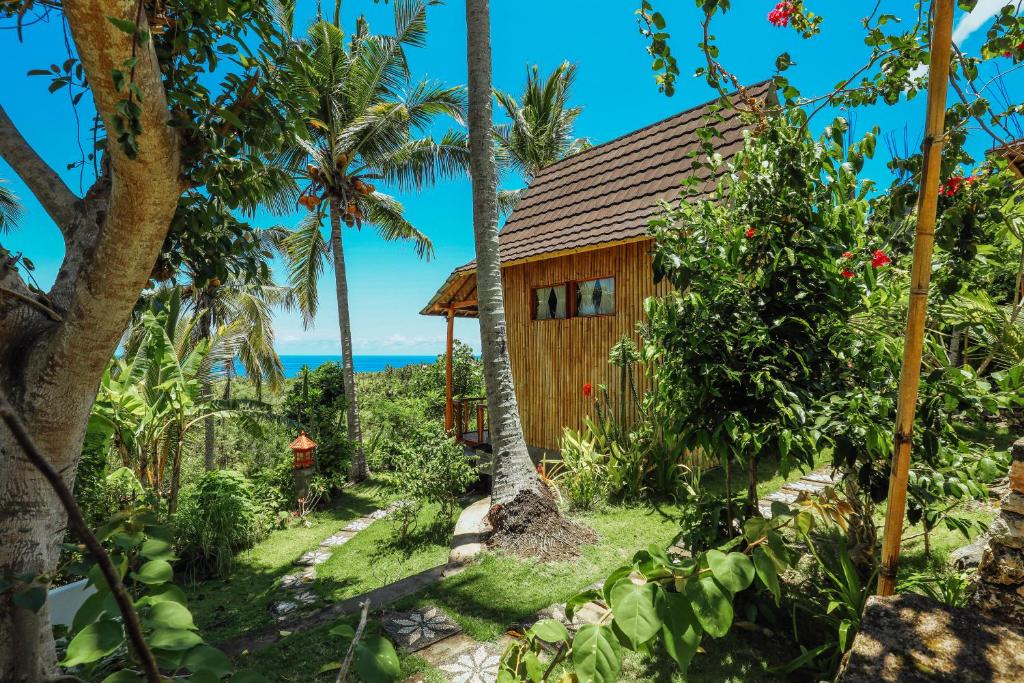 uma cabana na selva com palmeiras em Atuh Forest Cottage em Nusa Penida