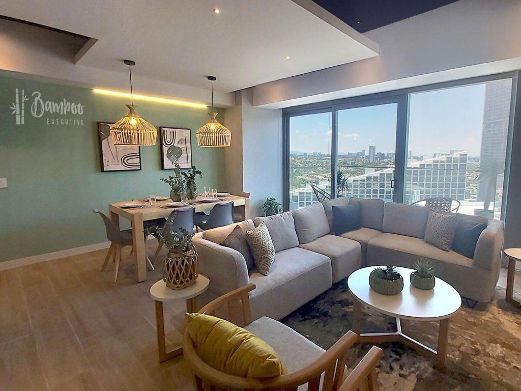 a living room with a couch and a table at Luxury Condo in Lobby33 near Andares By Bamboo in Guadalajara