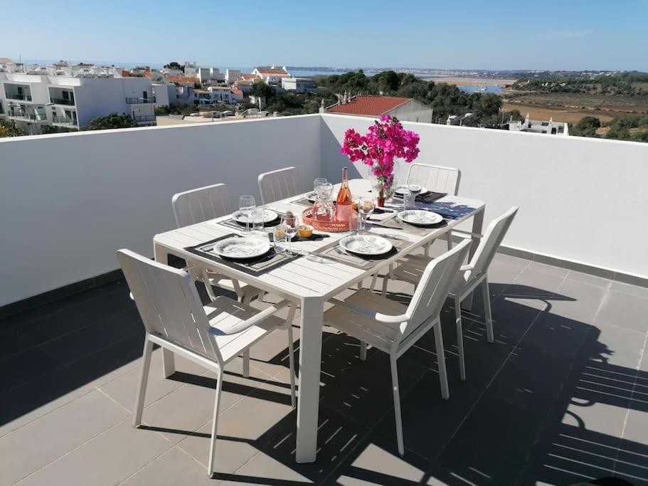 een witte eettafel en stoelen op een balkon bij Apartment 2 bedrooms , centre of Alvor, open view and private parking in Alvor