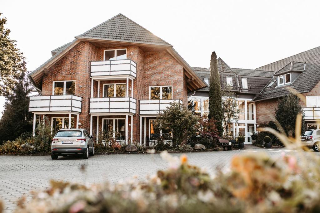 une maison avec une voiture garée devant elle dans l'établissement Akzent Hotel Zur Grünen Eiche, à Bispingen