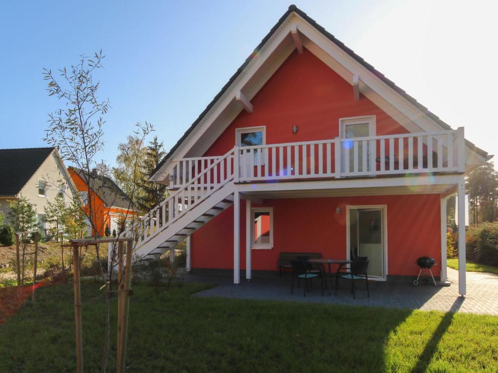 een rood huis met een terras en een tafel bij Apartment Müritz Ferienpark Röbel-6 by Interhome in Röbel