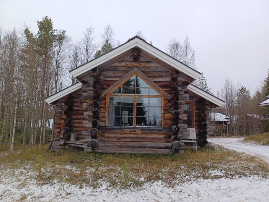 une cabane en rondins avec une grande fenêtre à l'avant dans l'établissement Rukan Kelostar, à Kuusamo