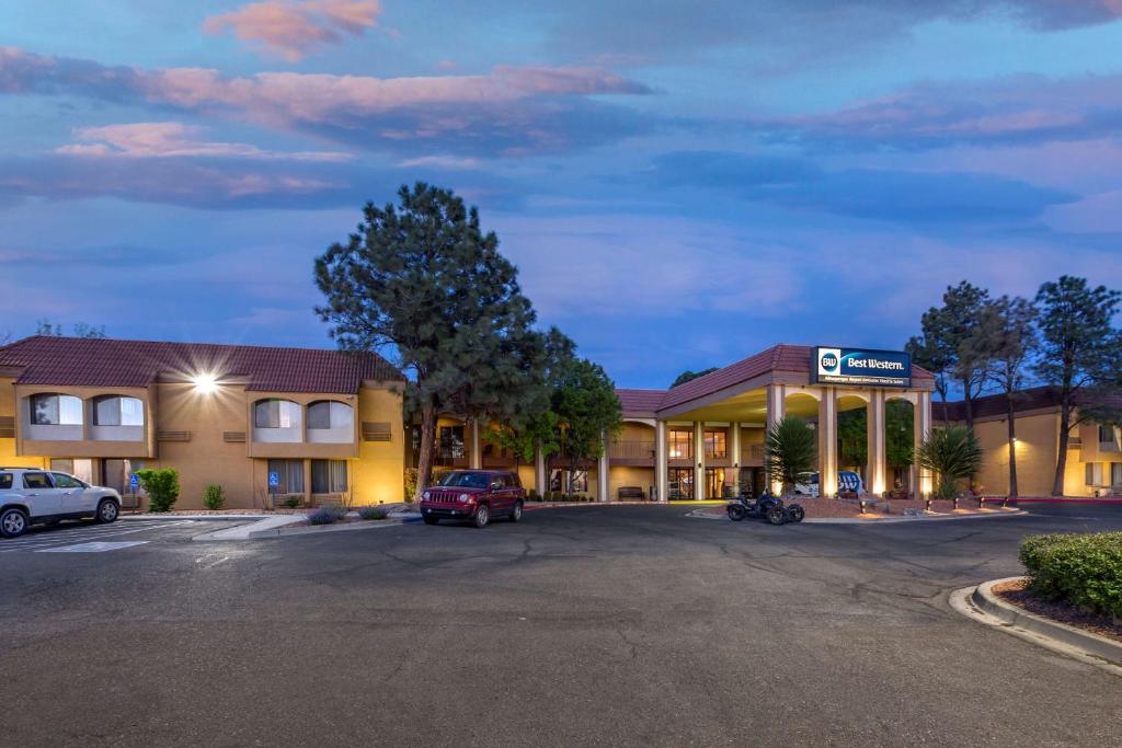 Best Western Airport Albuquerque InnSuites Hotel & Suites في ألباكيركي: فندق امامه موقف سيارات