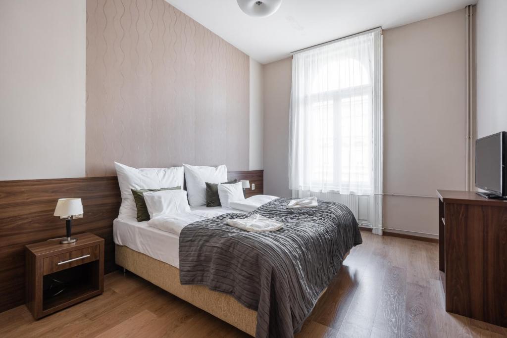 sypialnia z łóżkiem i telewizorem w obiekcie Elit Boutique Rooms- Best Location by BQA w Budapeszcie