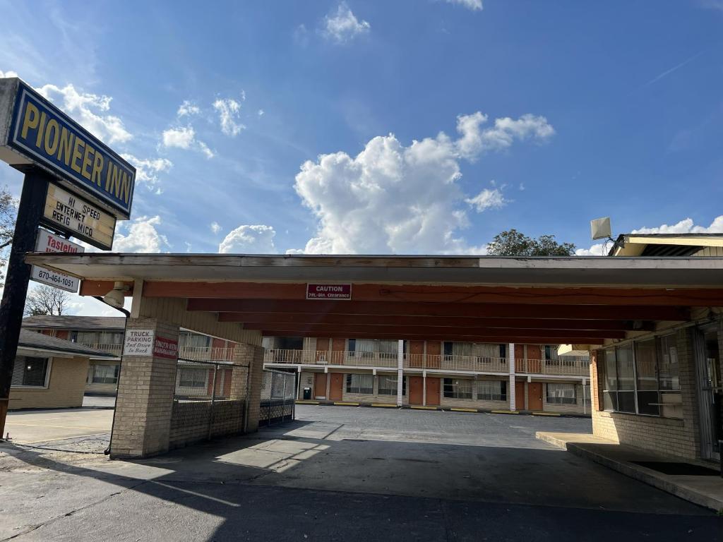 um posto de gasolina vazio em frente a um edifício em Pioneer INN em Arkadelphia