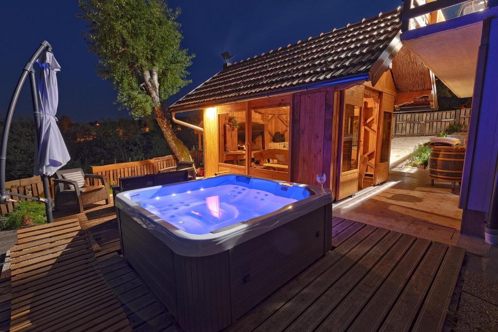 una vasca idromassaggio su una terrazza con una casa di Holiday Spa House Kostanjevec a Velika Gorica