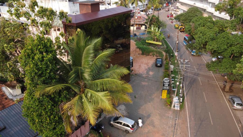 einen Blick über eine Stadtstraße mit einer Palme in der Unterkunft PPG HOMES in Ernakulam