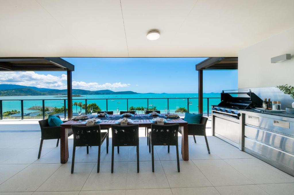 una sala da pranzo con tavolo e vista sull'oceano di 180 Degrees a Cannonvale