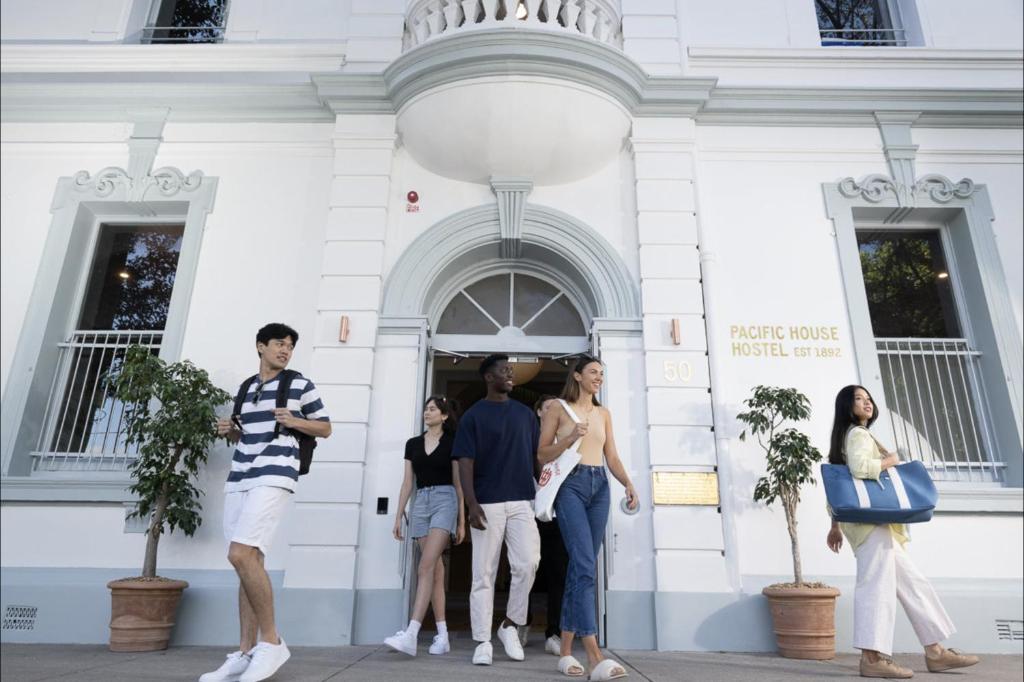 een groep mensen die buiten een gebouw staan bij The Pacific House in Sydney