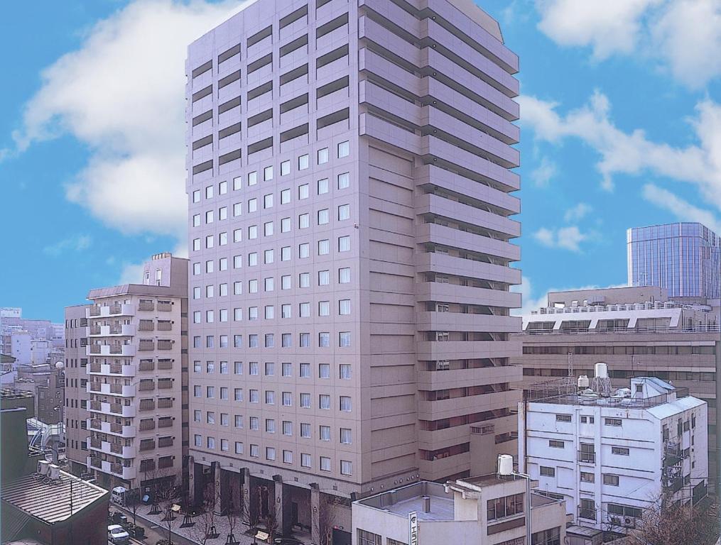 un edificio blanco alto en una ciudad con edificios en HOTEL MYSTAYS PREMIER Omori, en Tokio