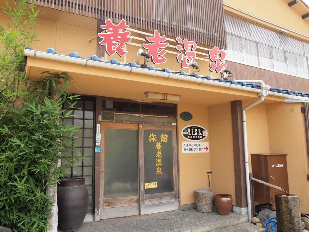 un edificio con dei cartelli sulla parte anteriore di Yourou Onsen Honkan a Onomichi