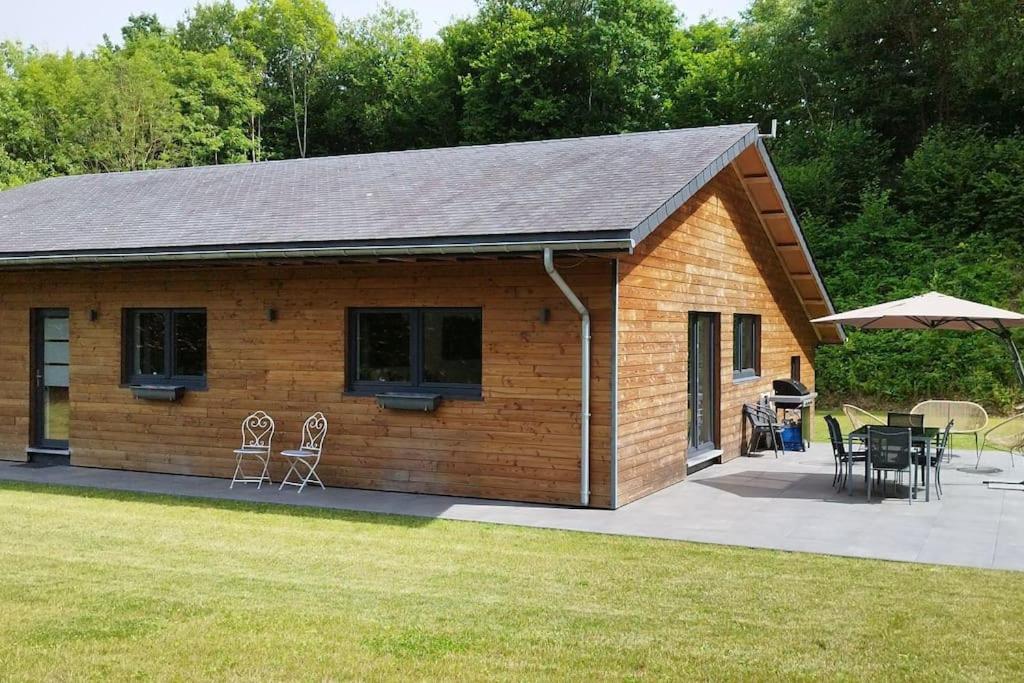 une cabane en rondins avec des chaises et des tables dans une cour dans l'établissement Le châlet Thomas, à Stavelot