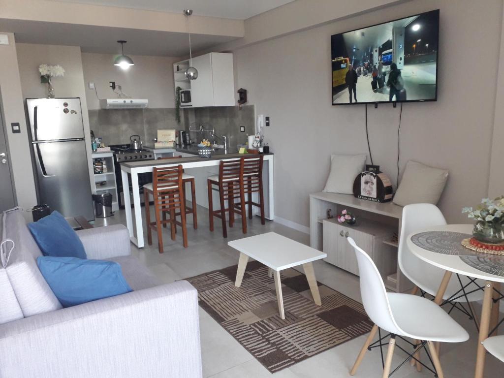 a kitchen and a living room with a table and chairs at Departamento Torre Murguía in San Salvador de Jujuy