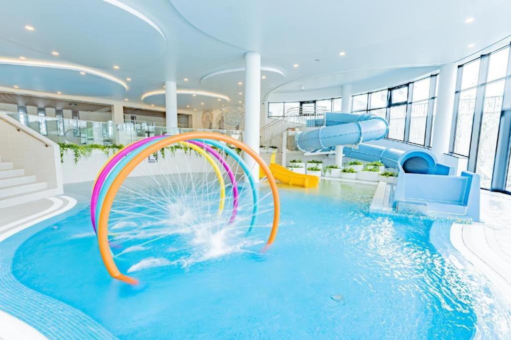 einem Pool mit Wasserrutsche in einem Gebäude in der Unterkunft Aqua Polanki Bodnar Apartments in Kołobrzeg