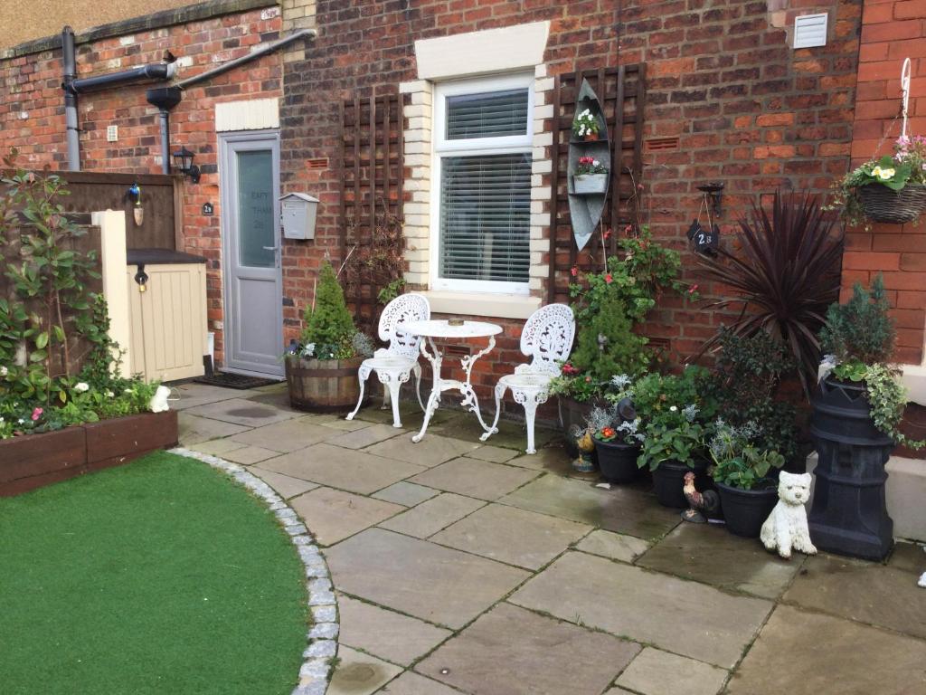 patio z 2 krzesłami i stołem oraz roślinami w obiekcie Leafy Lytham central Lovely ground floor 1 bedroom apartment with private garden In Lytham dog friendly w mieście Lytham St Annes