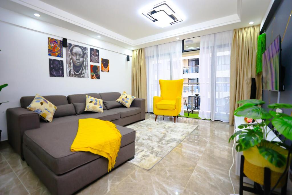 ein Wohnzimmer mit einem Sofa und einem gelben Stuhl in der Unterkunft Elite Luxury Apartments Kilimani - A 2 Bedroom Oasis of Serenity in Nairobi