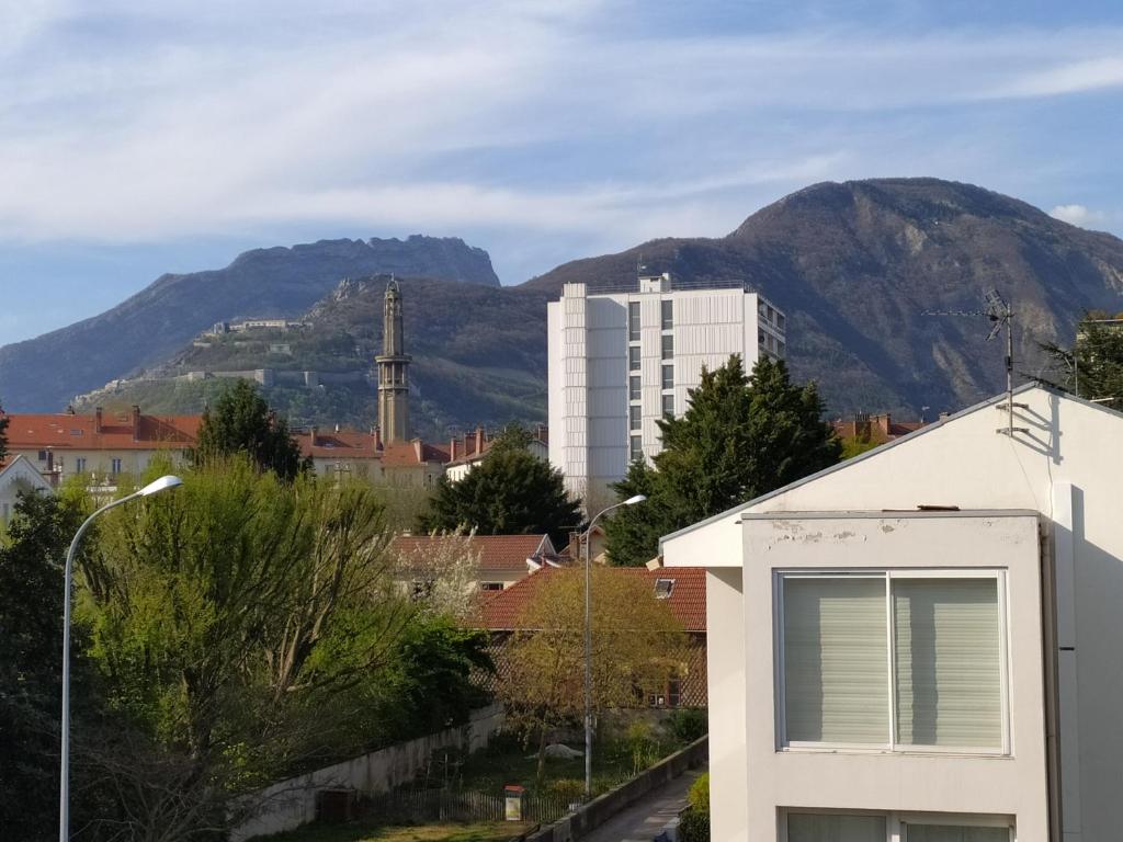 uitzicht op een stad met een berg op de achtergrond bij Chambres dans appartement partagé in Grenoble