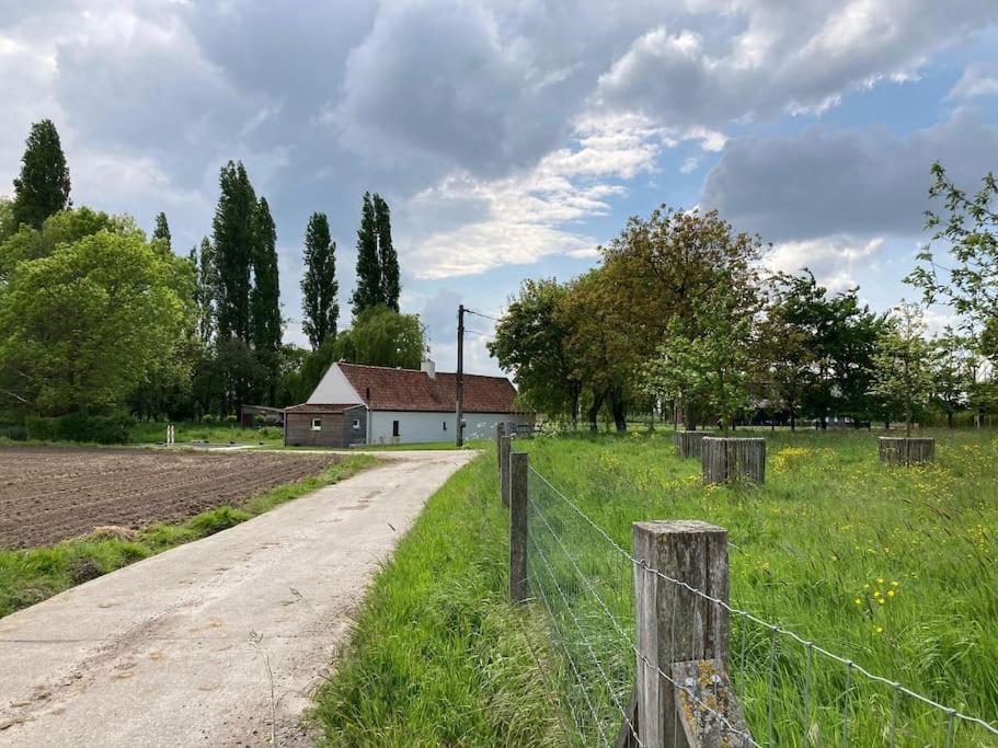 een onverharde weg naast een veld met een hek bij Cosy Cott, een verborgen logeerplek in het landelijke Poeke. in Aalter