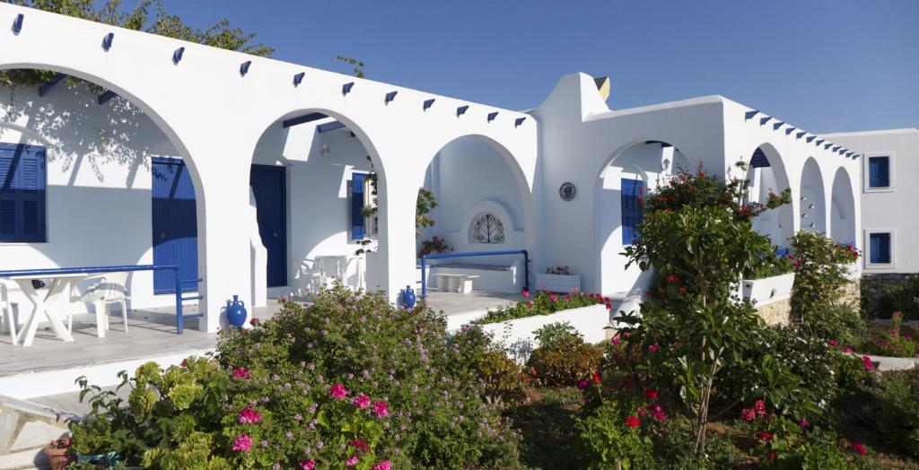 un edificio blanco con arcos y flores en Bungalows Marina, en Naousa