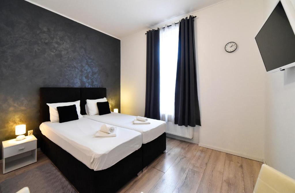 una camera con due letti e una grande finestra di Virtus Apartments and Rooms with Free Private Parking a Zagabria