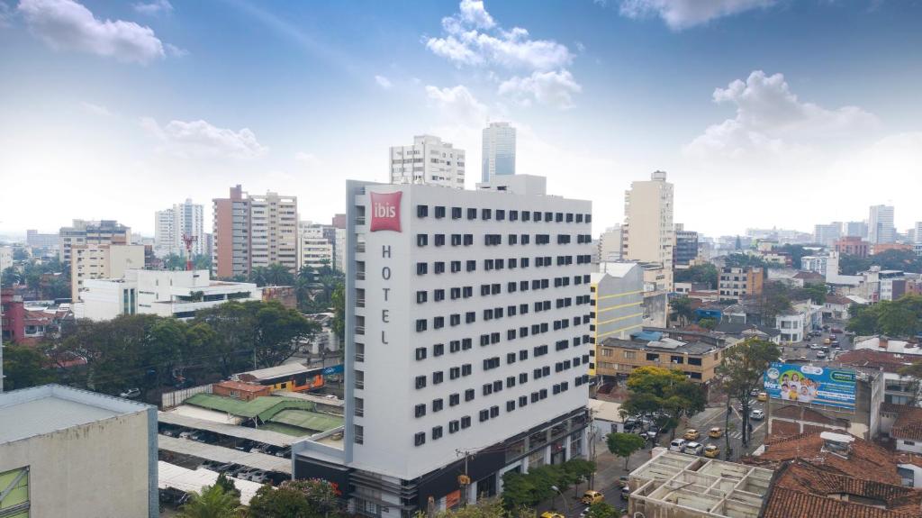 een hoog wit gebouw in een stad met gebouwen bij Hotel Ibis Cali Granada in Cali