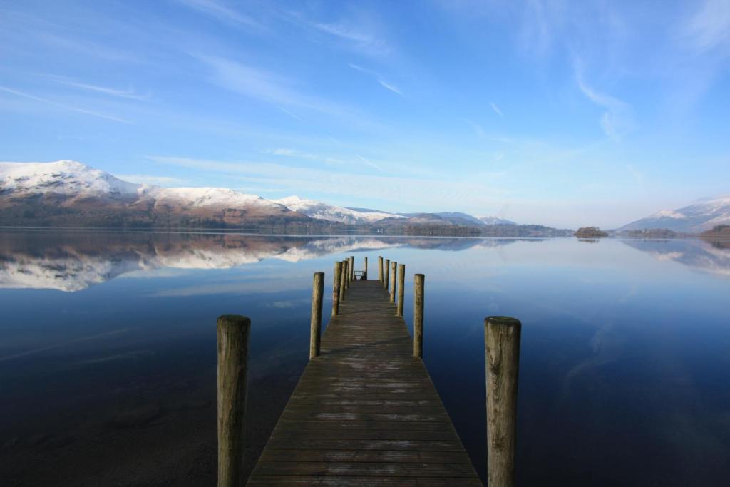 un quai sur un lac avec des montagnes enneigées dans l'établissement The Mary Mount Hotel, à Keswick