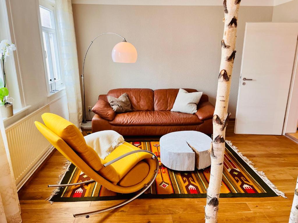 ein Wohnzimmer mit einem Sofa und einem Baum in der Unterkunft Kuschelige helle Ferienwohnung in Gotha