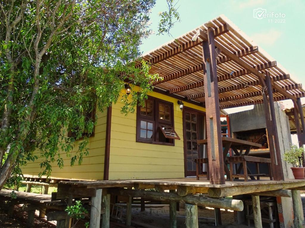 una pequeña casa amarilla con techo de madera en Un Sueño 2, en Punta del Diablo