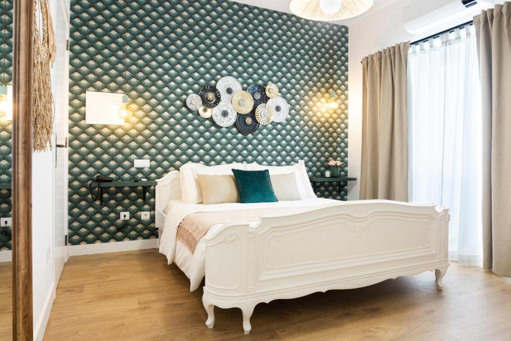 - une chambre dotée d'un lit blanc et d'un mur avec des points de polka dans l'établissement Lugar do Ourives Boutique Hotel, à Senhora das Febres