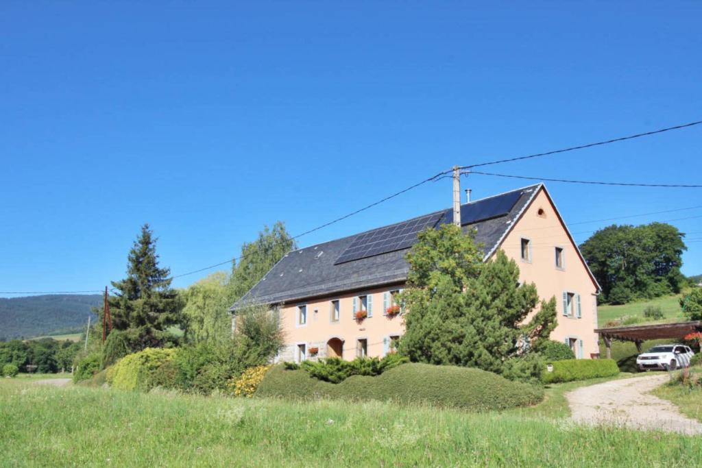 una gran casa blanca con techo negro en Gîte Les 4 Saisons, en Orbey