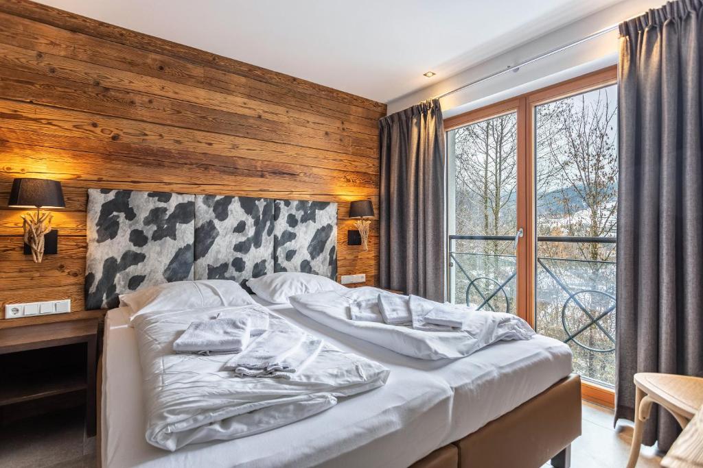 ein Schlafzimmer mit einem Bett und einem großen Fenster in der Unterkunft Mountain Lodge Leogang - Top4 in Leogang