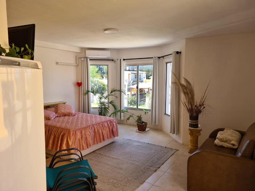 een slaapkamer met een bed, een bank en ramen bij Precioso apartamento a 1km de la playa. in Barra del Chuy