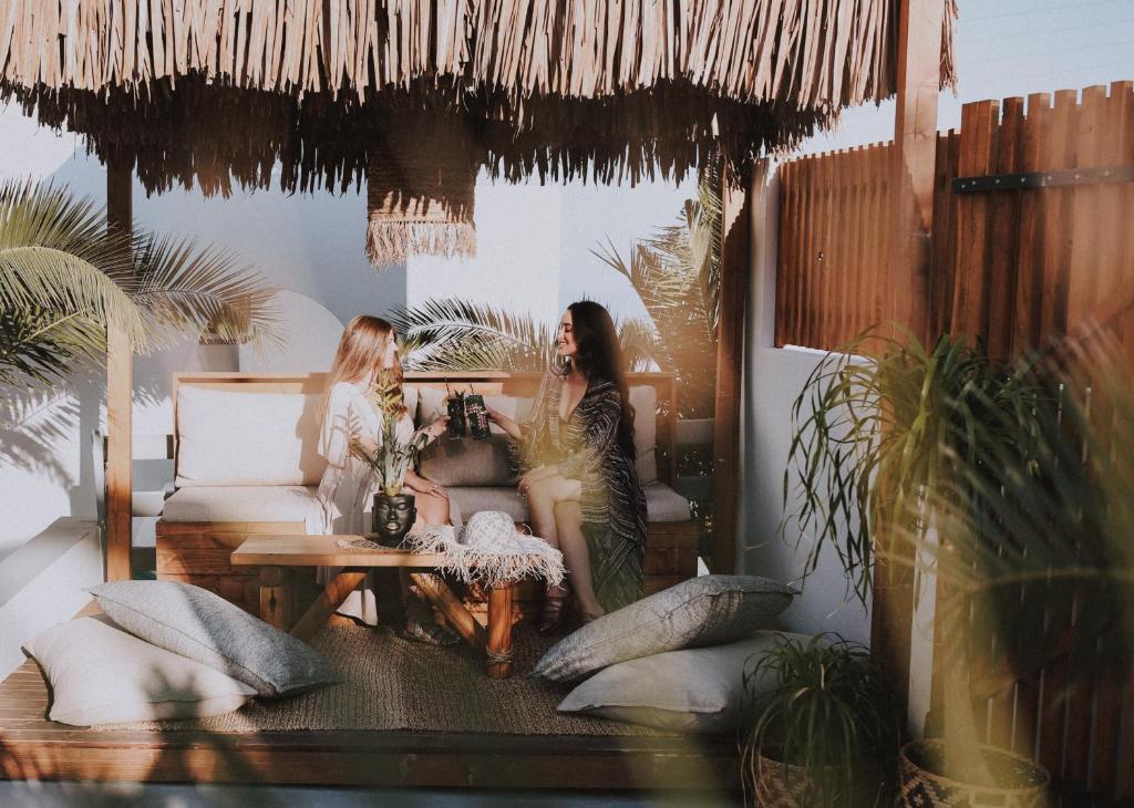 Dos mujeres sentadas en una habitación con plantas en Margarita Hotel, en Firostefani